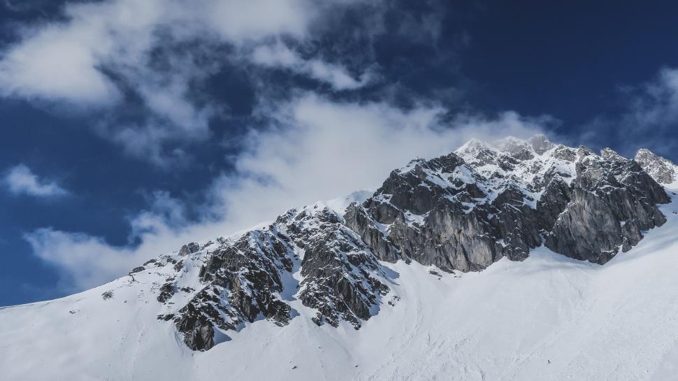 Free Image of Snow Covered Mountain Under Cloudy Blue Sky 