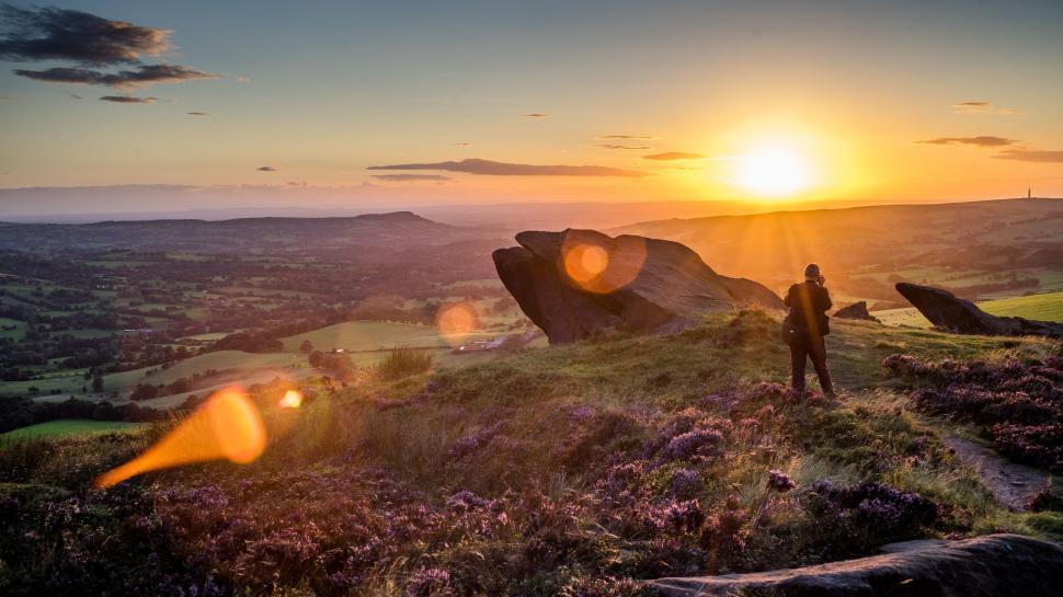 Free Image of Person Standing on Top of Hill at Sunset 