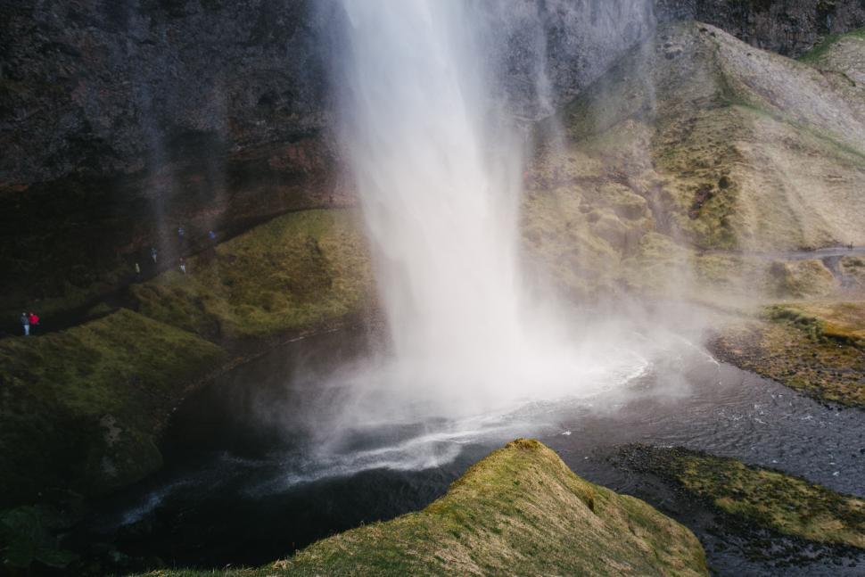 Free Image of Man Standing by Majestic Waterfall 