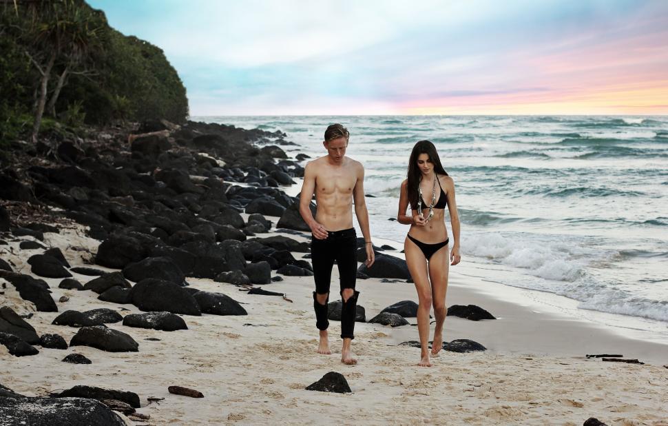 Free Image of Man and Woman Walking on the Beach 