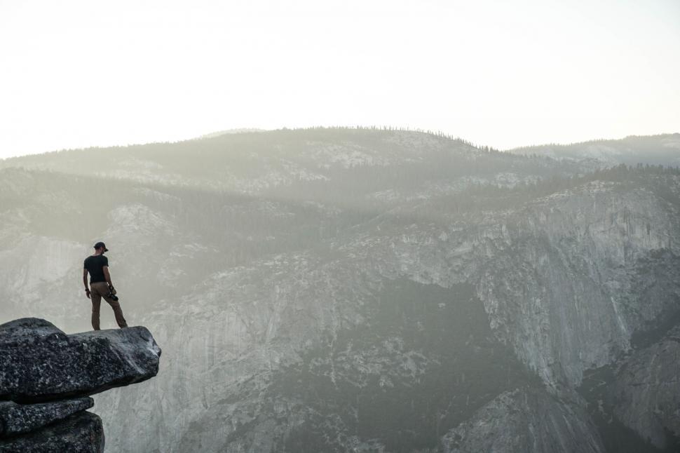 Free Image of Man Standing on Top of Cliff 