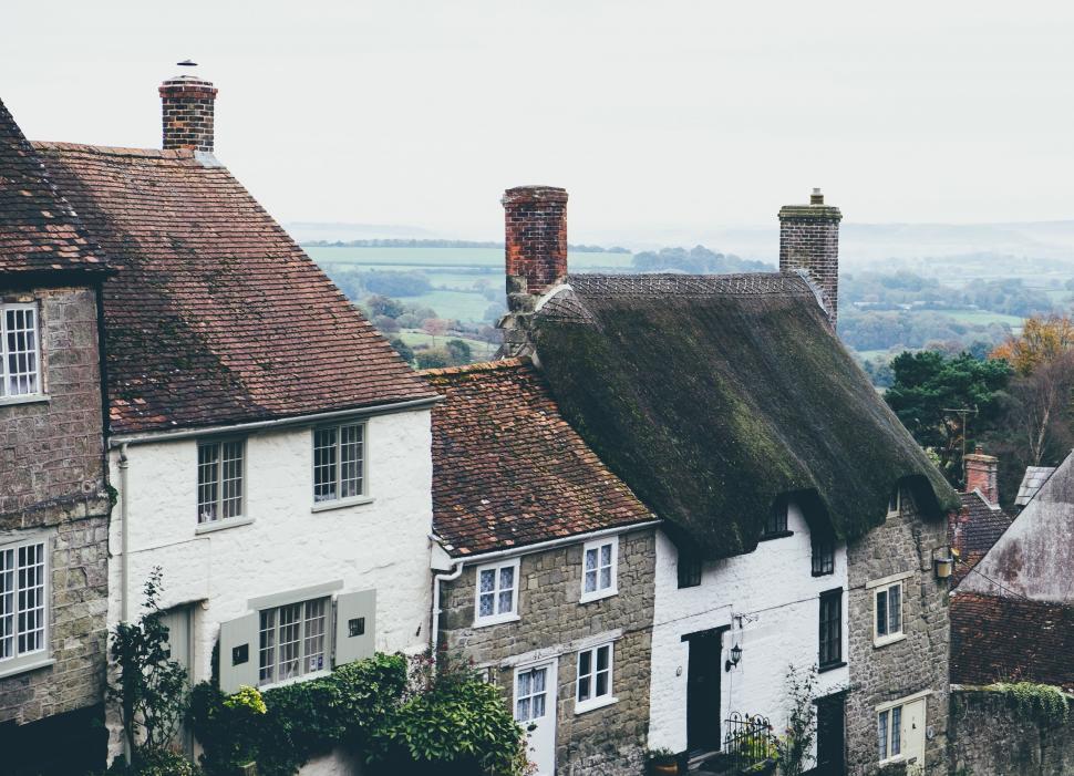 Free Image of Row of Houses With Clock Tower in Background 