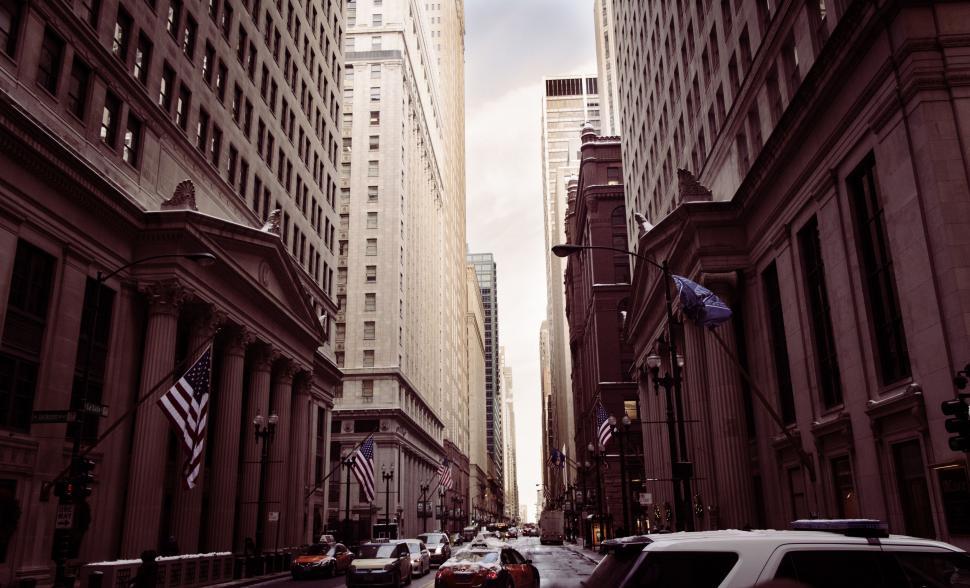 Free Image of Car Driving Down Street Next to Tall Buildings 