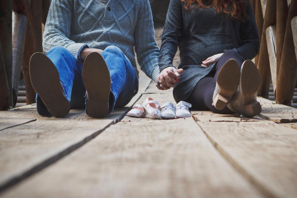 Free Image of A Man and a Woman Sitting on a Wooden Floor 