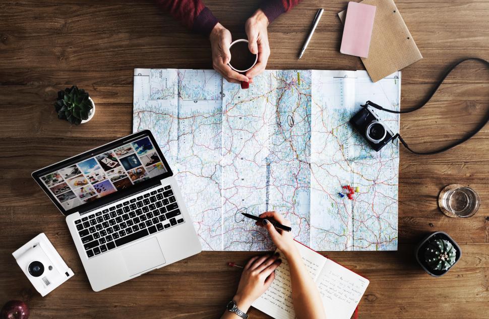Free Image of Person Sitting at Table With Laptop and Map 