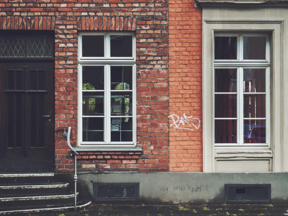 Free Image of Red Brick Building With White Windows and Black Door 