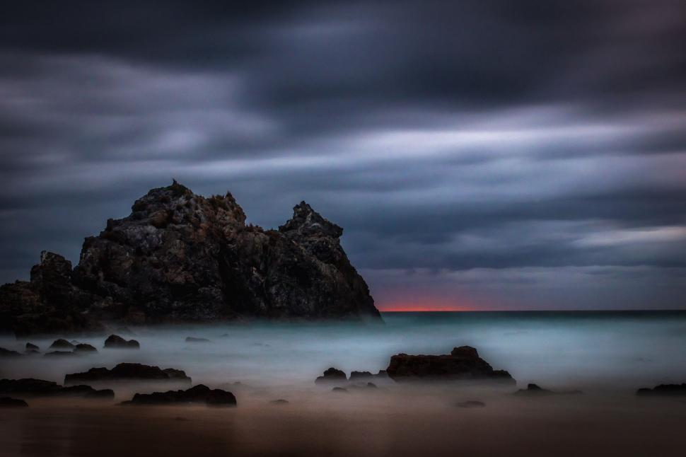 Free Image of Large Rock in the Middle of a Body of Water 