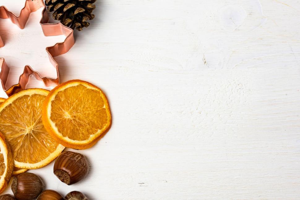 Free Image of Orange Slices, Nuts, and Pine Cones on White Table 