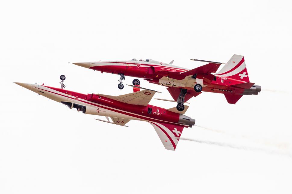 Free Image of Two Red and White Airplanes Flying in the Sky 