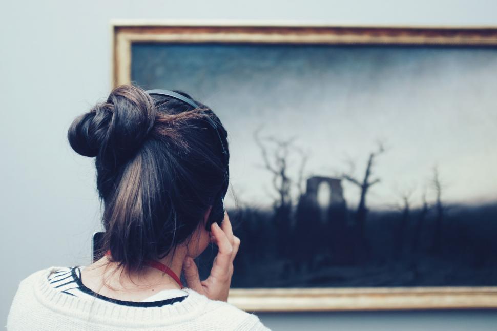 Free Image of Woman Talking on Cell Phone in Front of Painting 