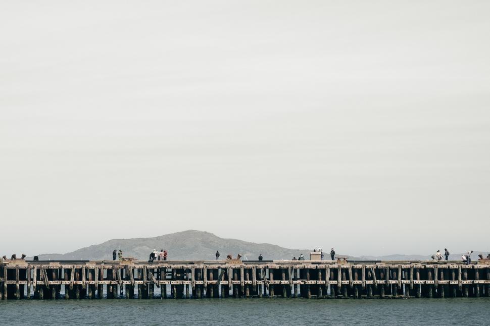 Free Image of People Standing on Top of a Long Pier 