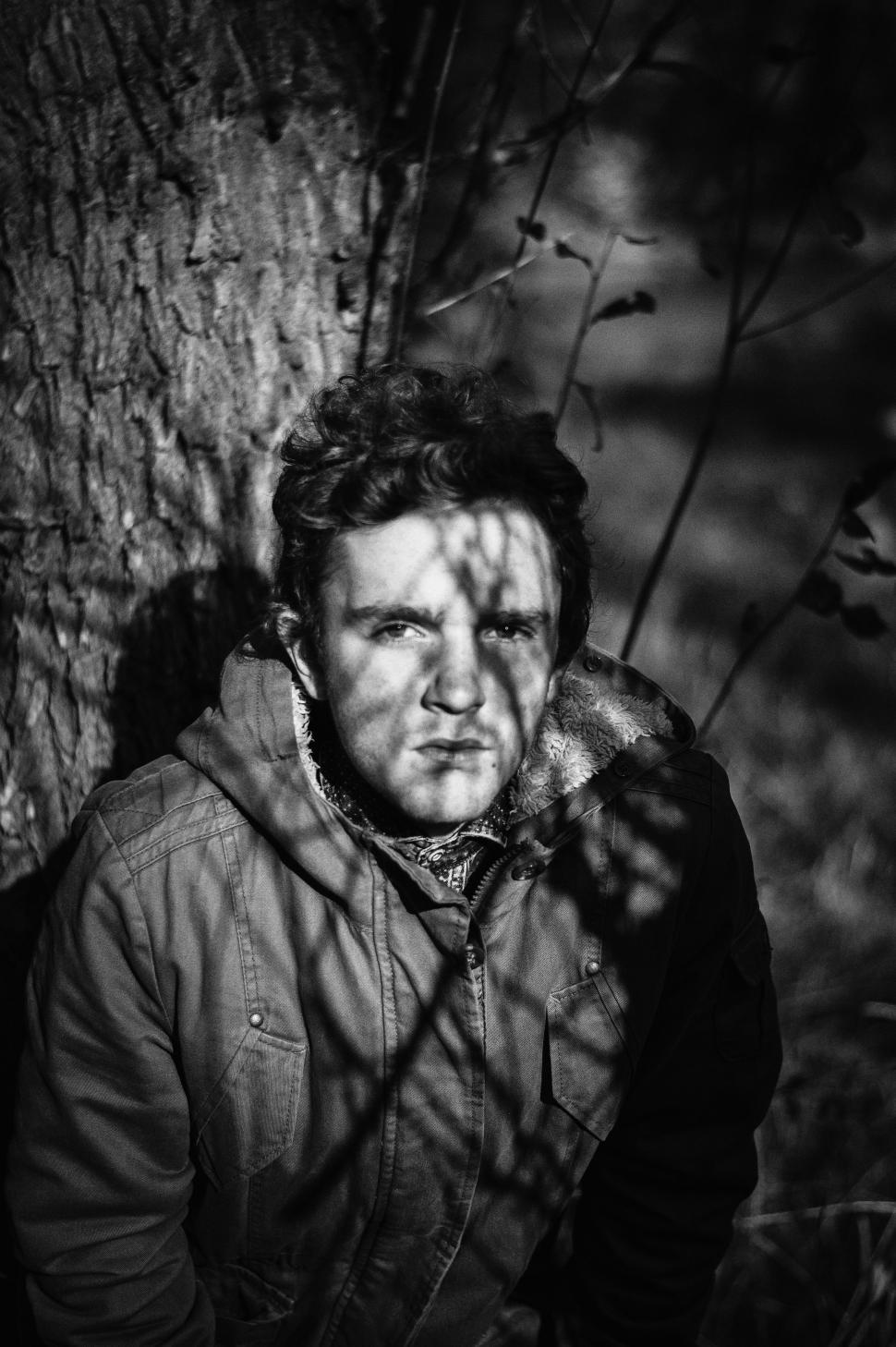 Free Image of Man Leaning Against Tree 