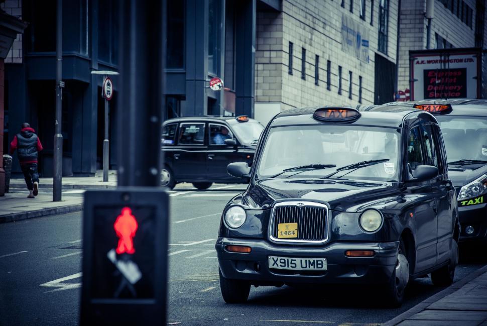 Free Image of Taxi Cab Driving by Traffic Light 