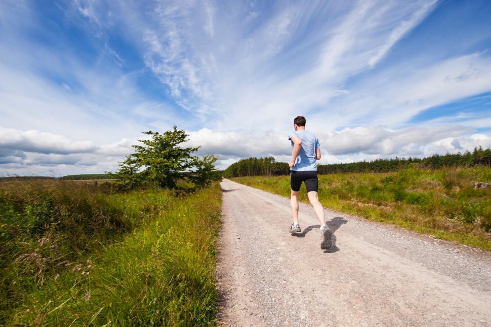 Free Image of Man Running Down Dirt Road in Field 