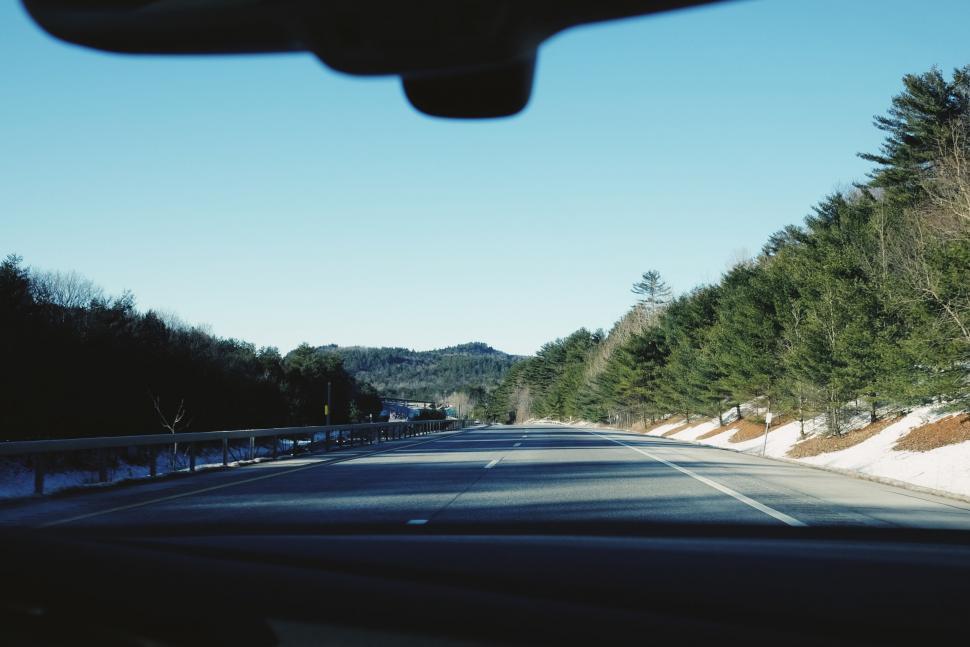 Free Image of Car Driving Down Road Beside Forest 