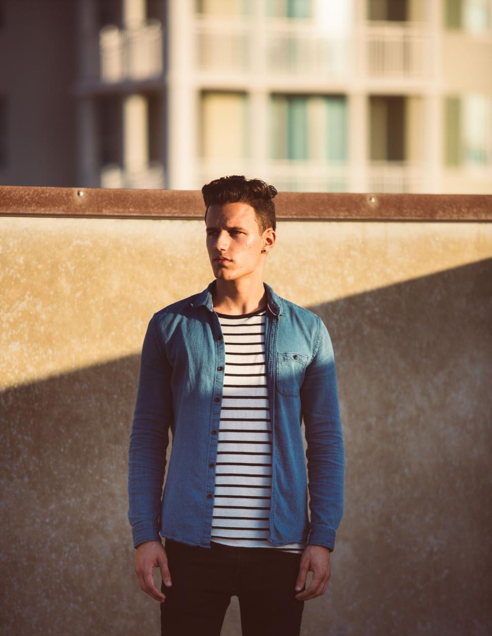 Free Image of Young Man Standing in Front of Wall 