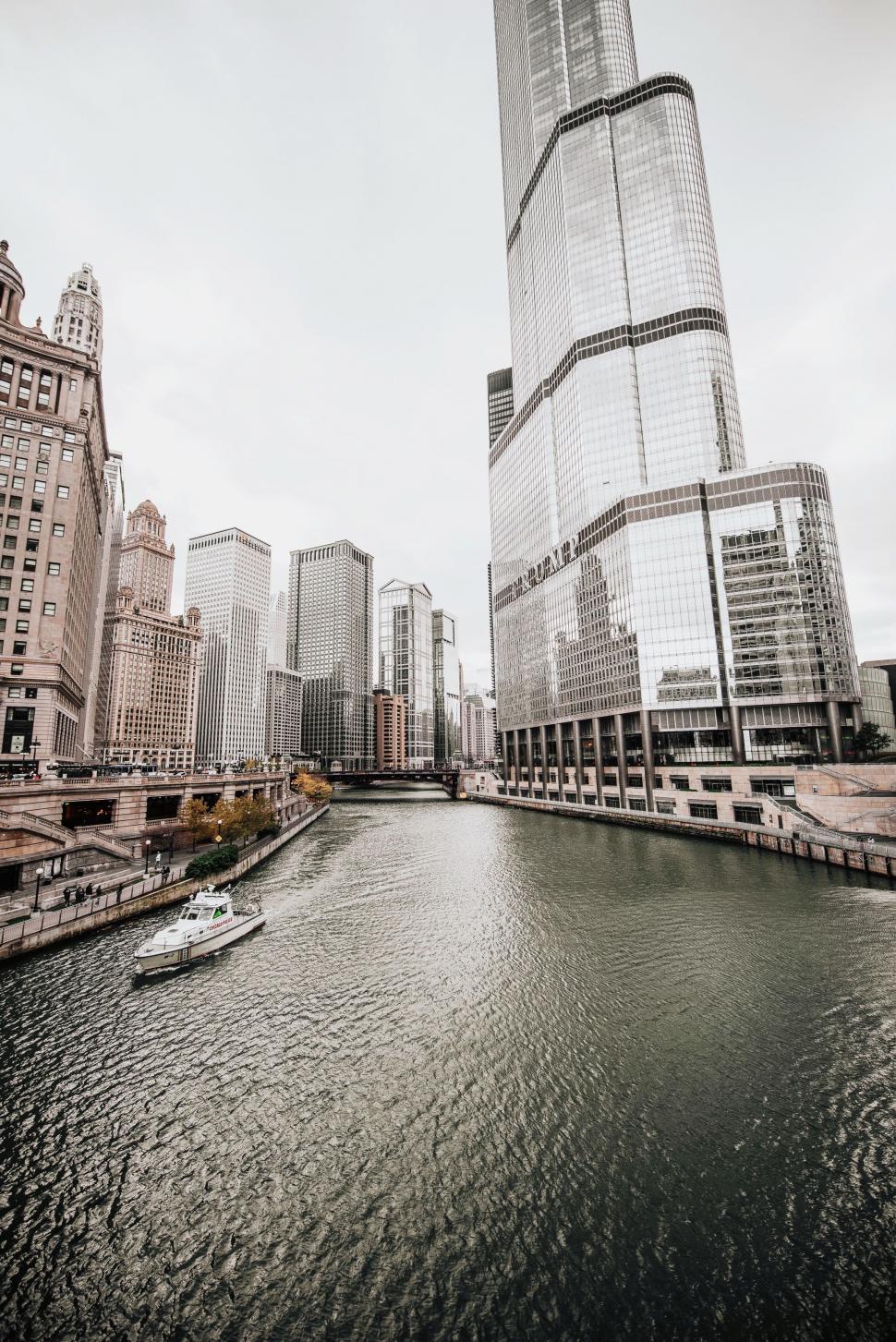 Free Image of Boat Traveling Down River Next to Tall Buildings 