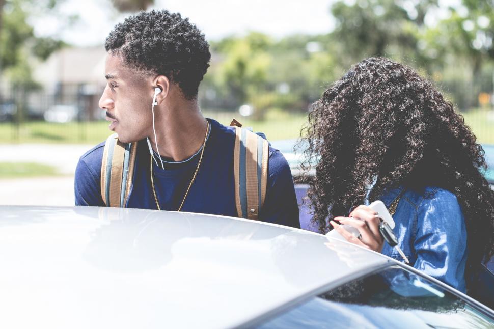 Free Image of Couple Standing Next to Car 