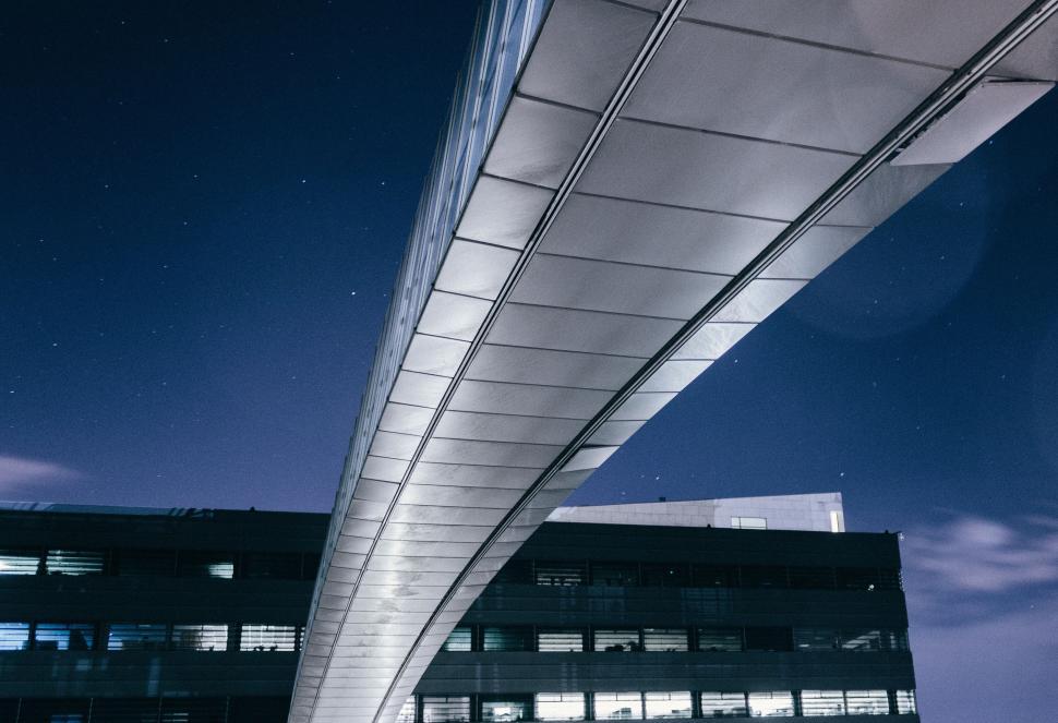 Free Image of Tall Building With Long Bridge Spanning Across 