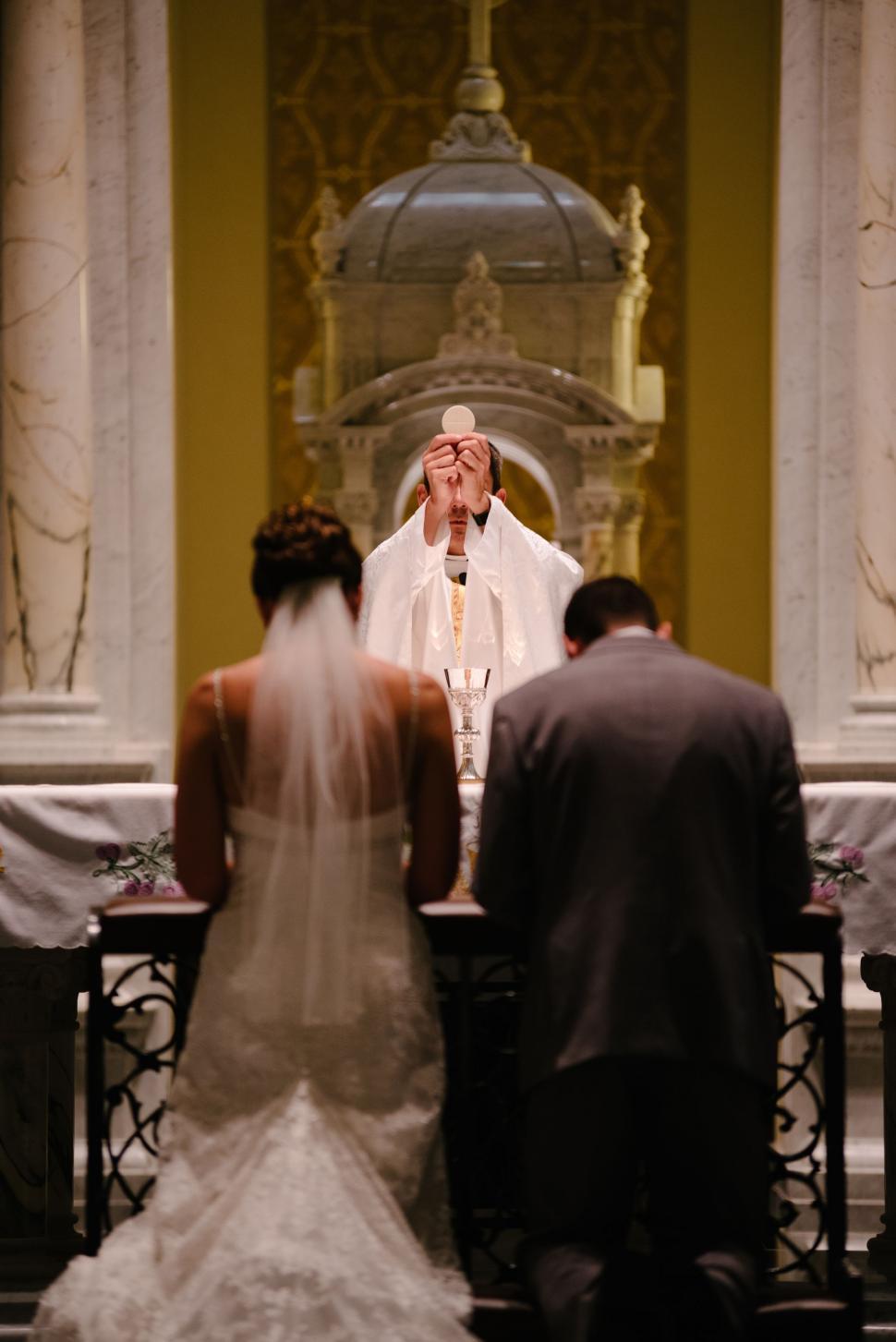 Free Image of Man and Woman Standing in Front of Priest 