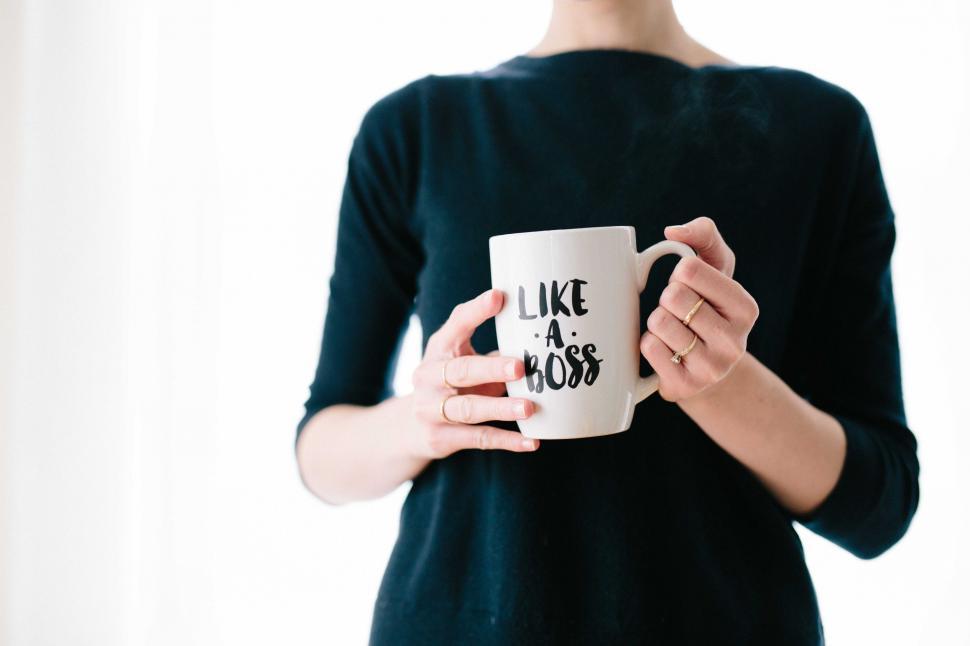 Free Image of Woman Holding a Coffee Mug That Says Like a Boss 