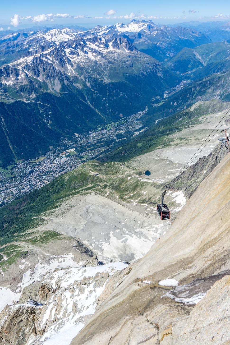 Free Image of Man Riding Ski Lift Up Snow Covered Mountain 