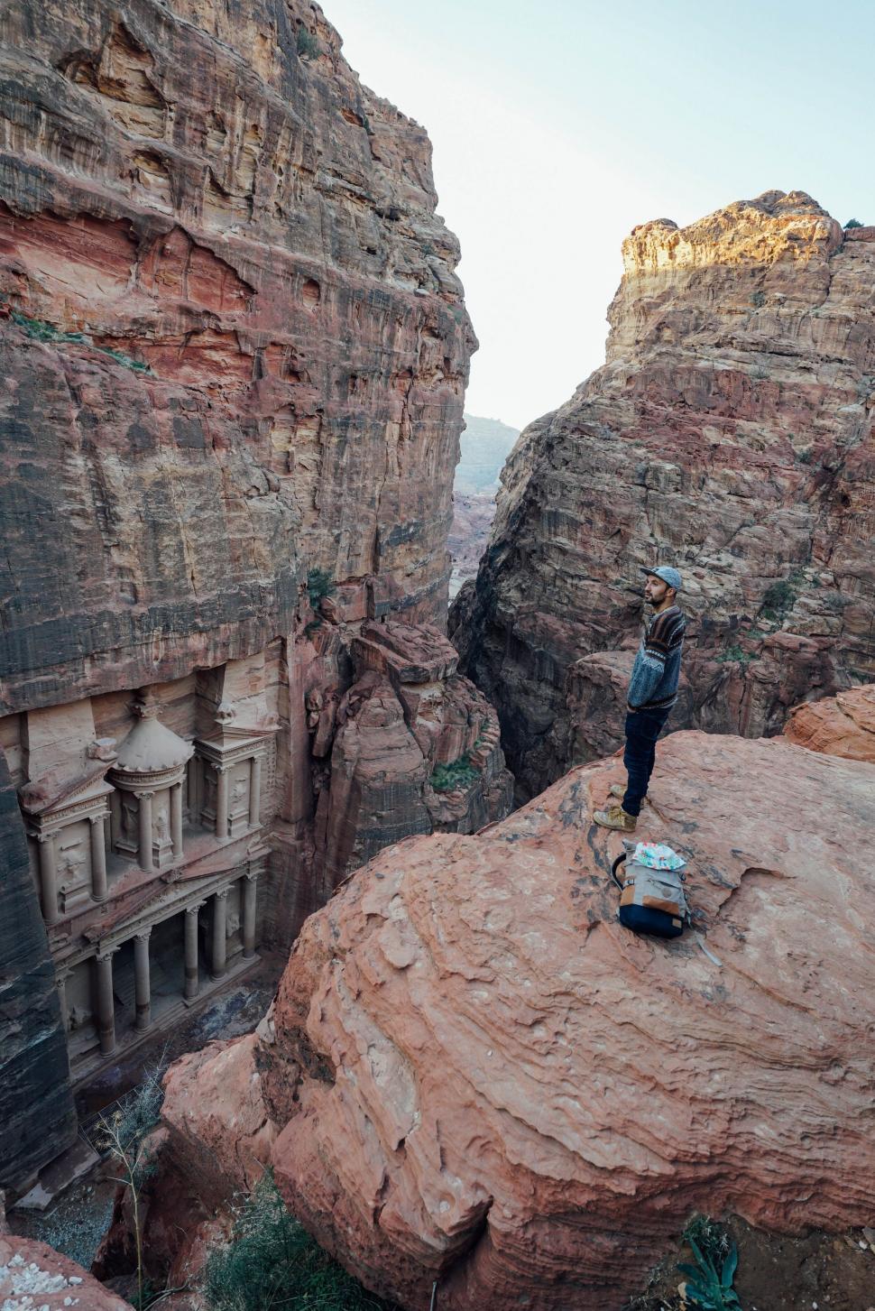 Free Image of Man Standing on Top of Large Rock 