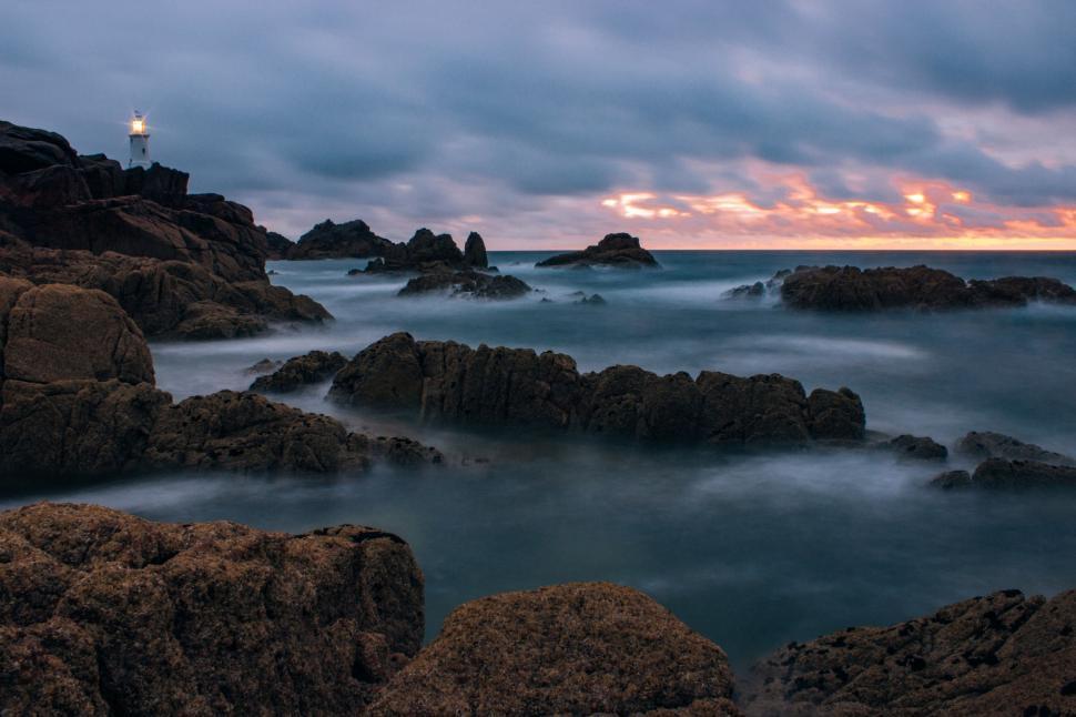 Free Image of Lighthouse on Rocky Shore at Sunset 