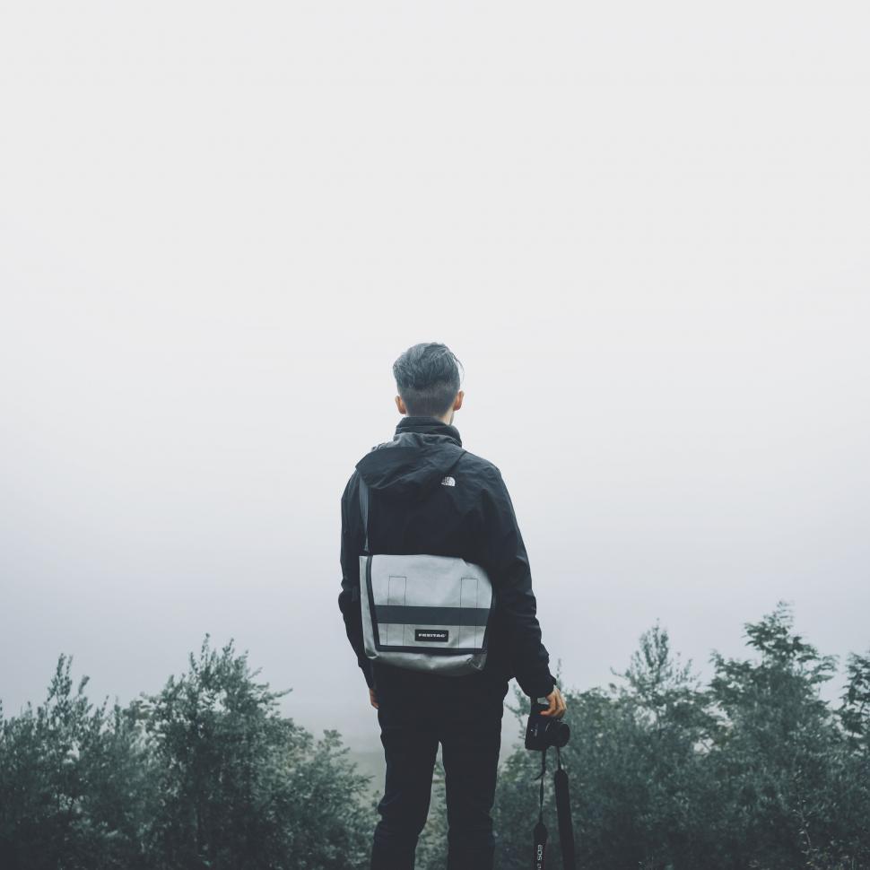 Free Image of Man Standing on Top of a Hill Holding Skis 