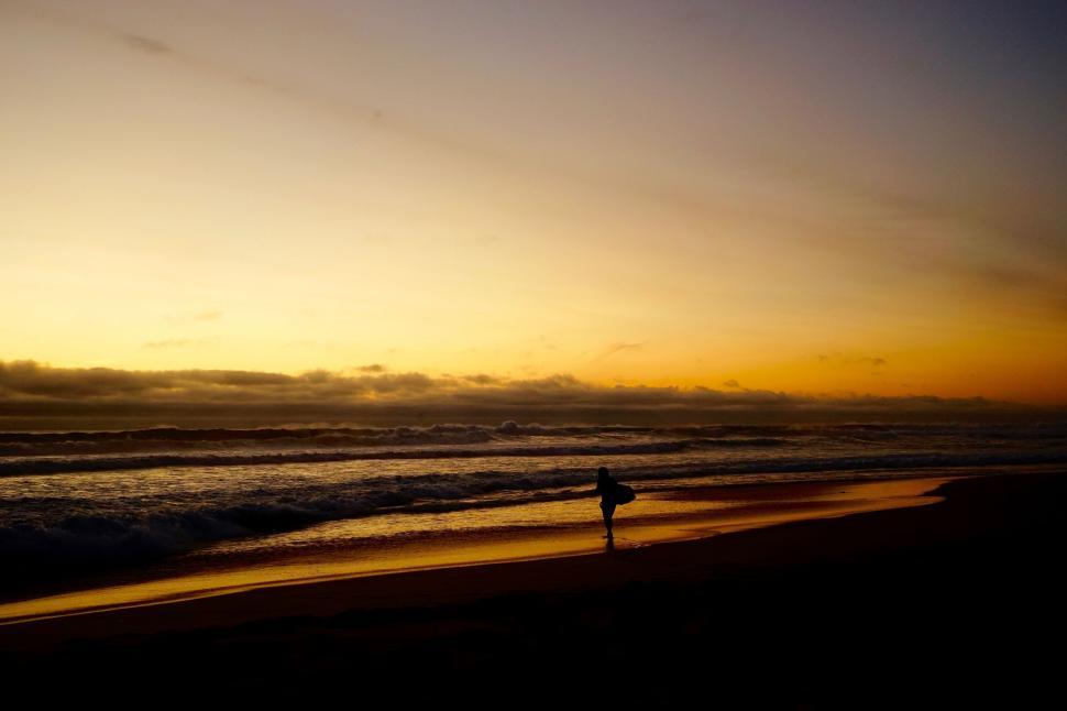 Free Image of Person Walking on Beach at Sunset 