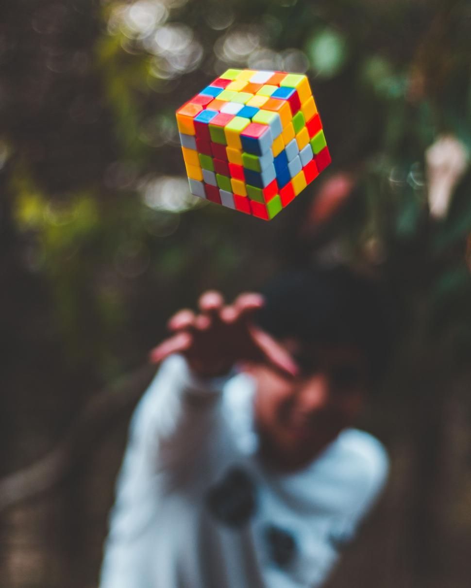 Free Image of Person Holding Rubik Cube Up in the Air 