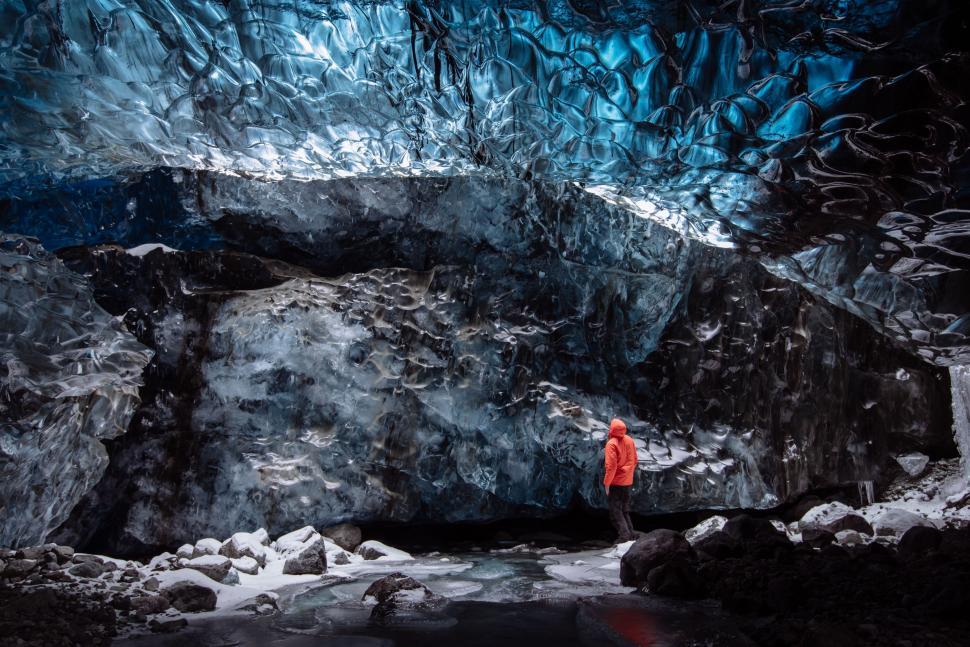Free Image of Man in Red Jacket Standing in Cave 
