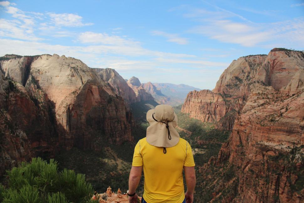 Free Image of Man Standing on Top of Mountain Overlooking Valley 