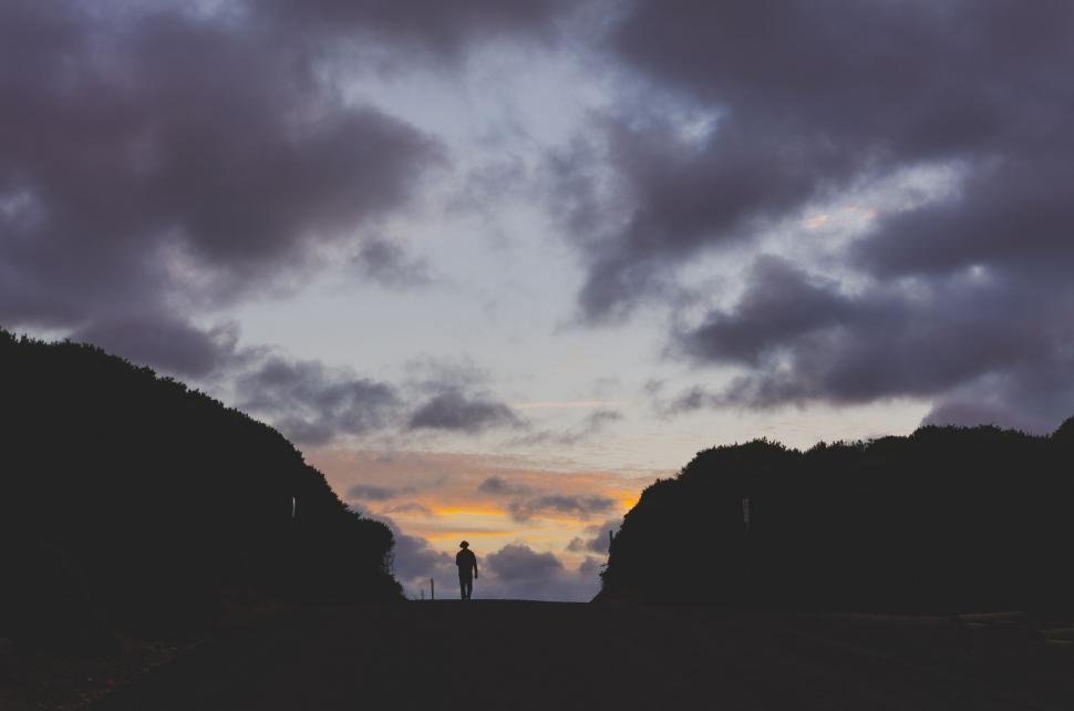 Free Image of Person Standing in Field Under Cloudy Sky 