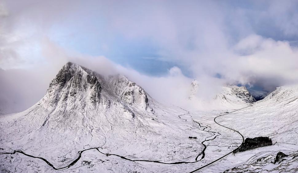 Free Image of Snow-Covered Mountain and Clouds Under Blue Sky 