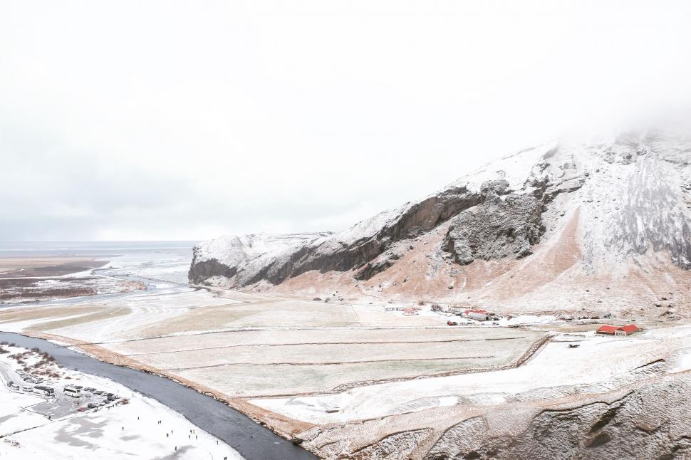 Free Image of Snow-Covered Mountain With River Running Through 