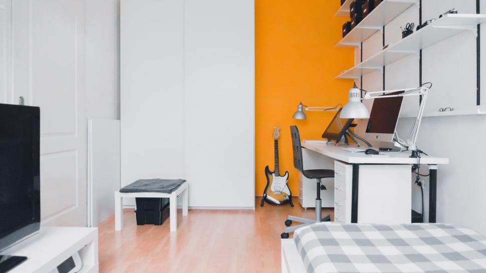 Free Image of Modern Bedroom With Bed, Desk, and Television 