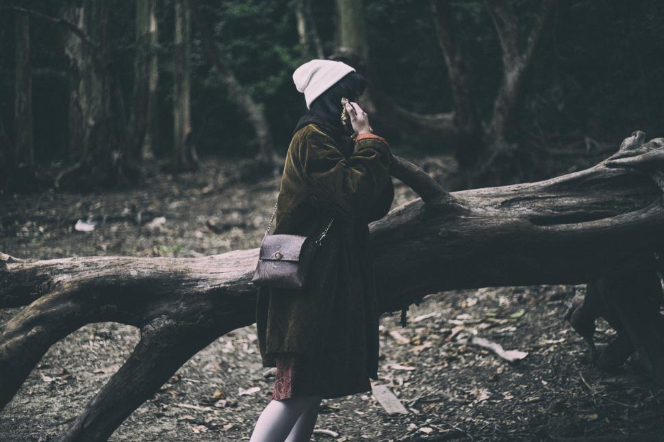 Free Image of Woman Standing Next to Fallen Tree in Forest 