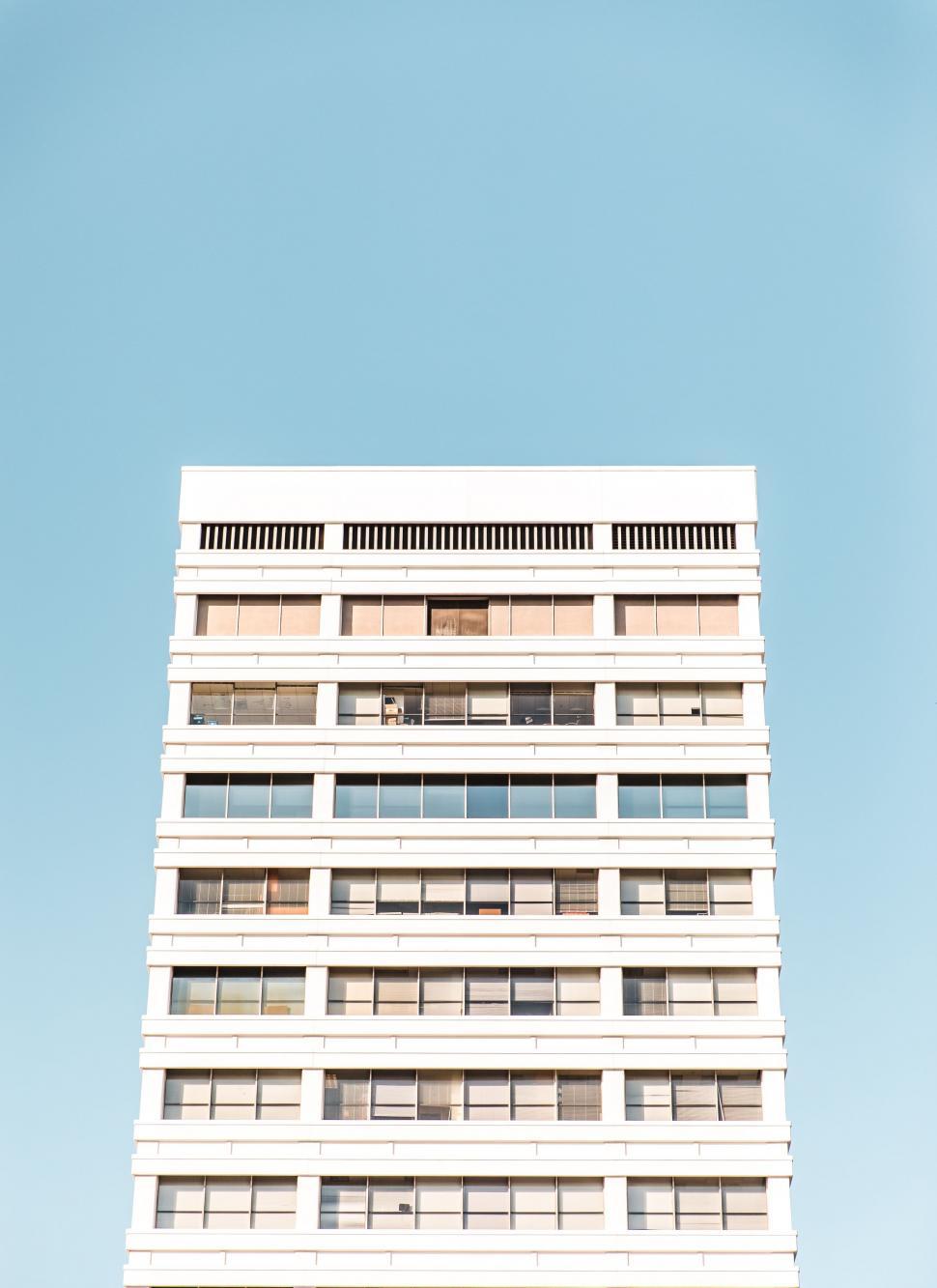Free Image of Tall White Building With Lots of Windows 