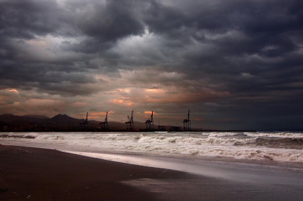 Free Image of Cloudy Sky Over Beach With Waves 
