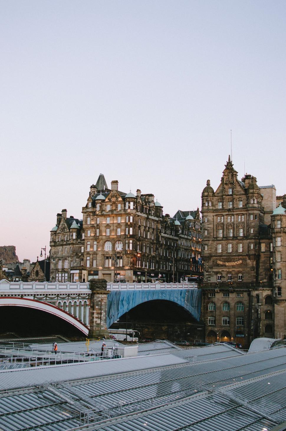 Free Image of Train Passing Tall Building by Bridge 