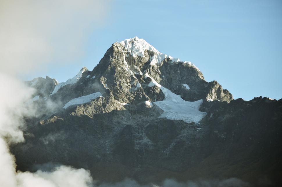 Free Image of Majestic Mountain Shrouded in Snow and Clouds 