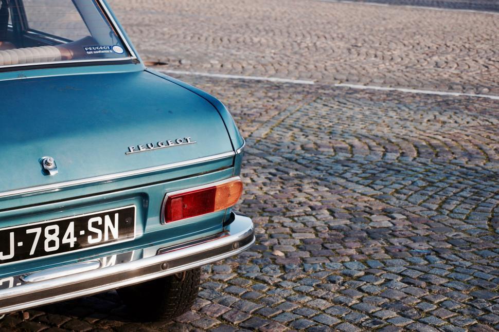 Free Image of Small Blue Car Parked on Cobblestone Street 