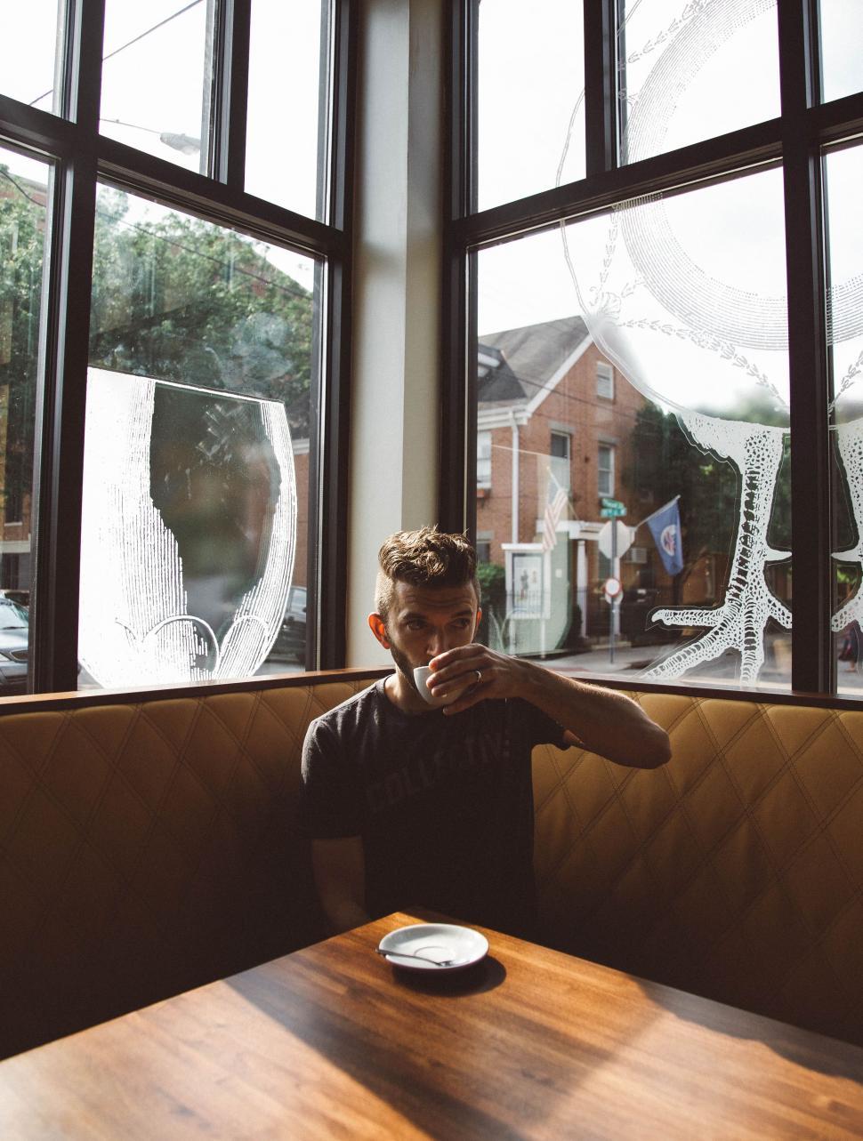 Free Image of Person Sitting at Table in Front of Window 