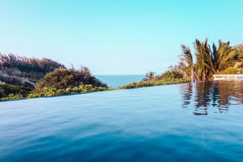 Free Image of Tranquil Oasis: Large Swimming Pool Surrounded by Trees and Water 