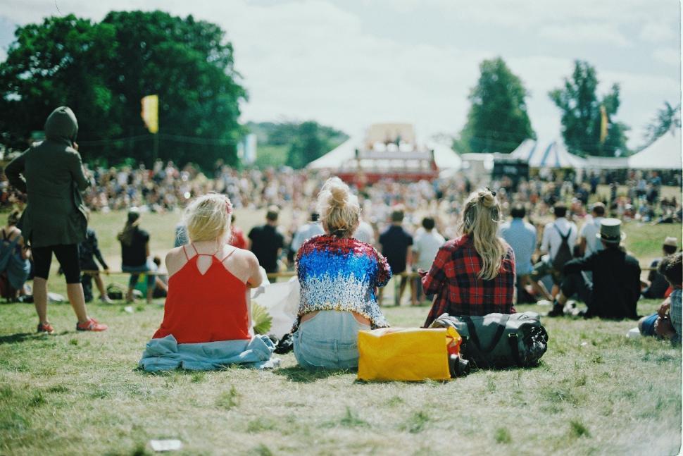 Free Image of Group of People Sitting on Top of a Grass Covered Field 
