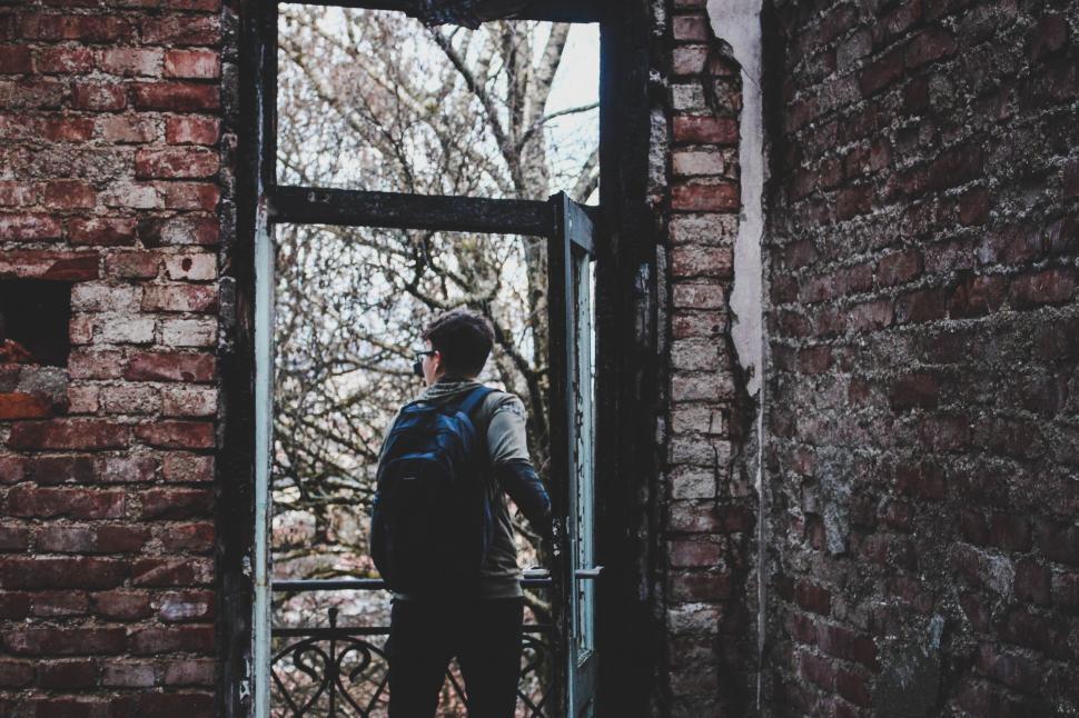Free Image of Man With Backpack Standing in Doorway 