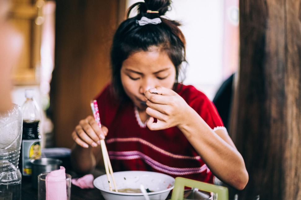 Free Image of Woman Eating Bowl of Food at Table 