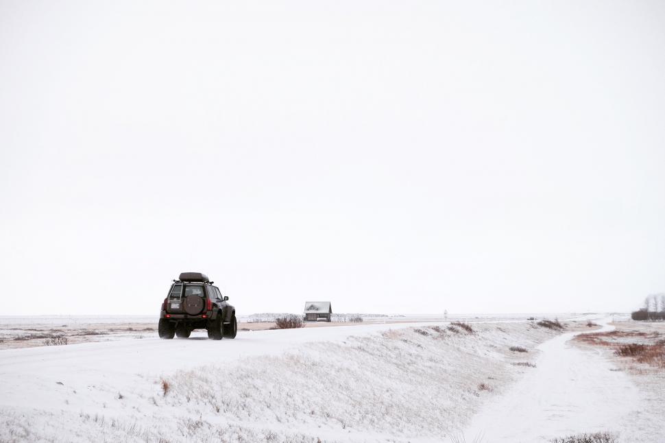 Free Image of Truck Driving Down Snow Covered Road 