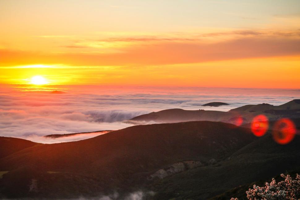 Free Image of Sun Setting Over Clouds in the Mountains 